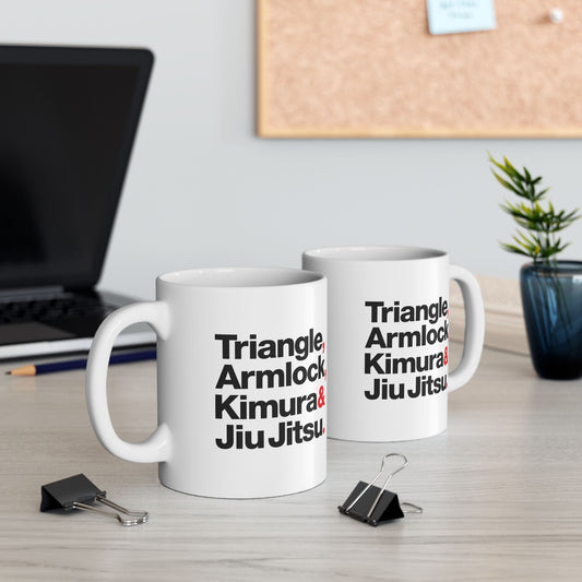 Two white mugs with martial arts terms on a desk with office supplies.