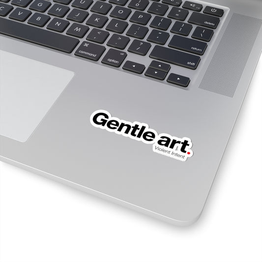 Laptop with a 'Gentle art, Violent Intent' sticker on the palm rest area.