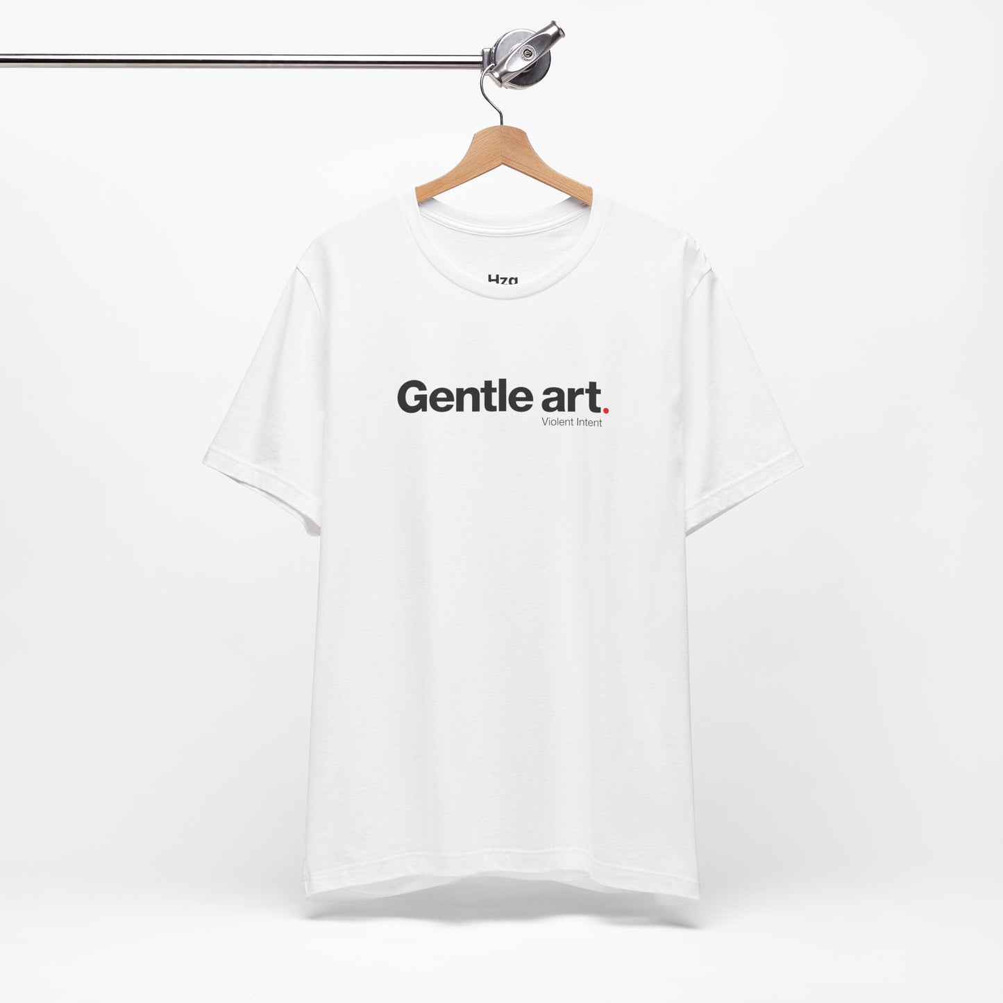 White t-shirt with 'Gentle art' text on a hanger against a white background