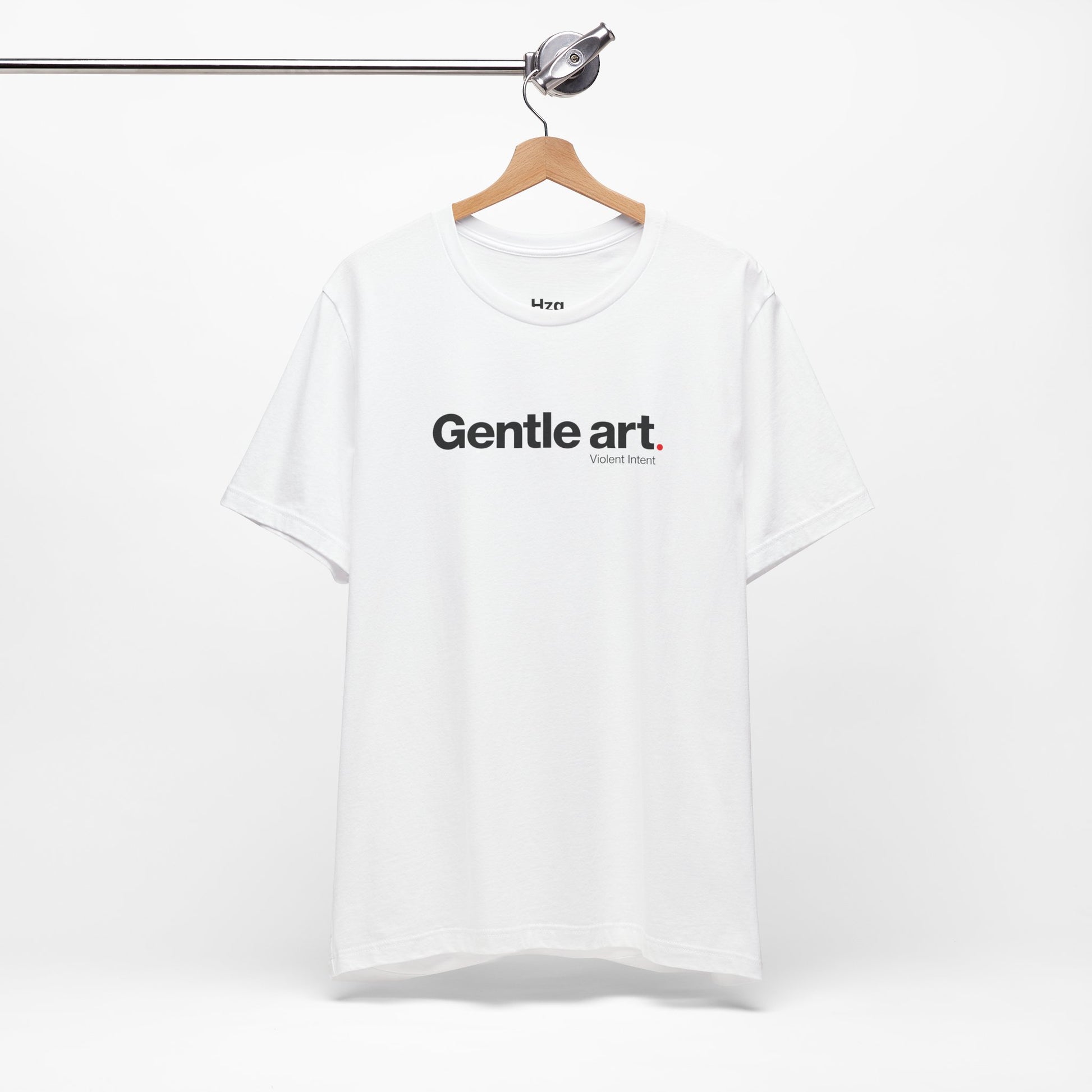 White t-shirt with 'Gentle art' text on a hanger against a white background