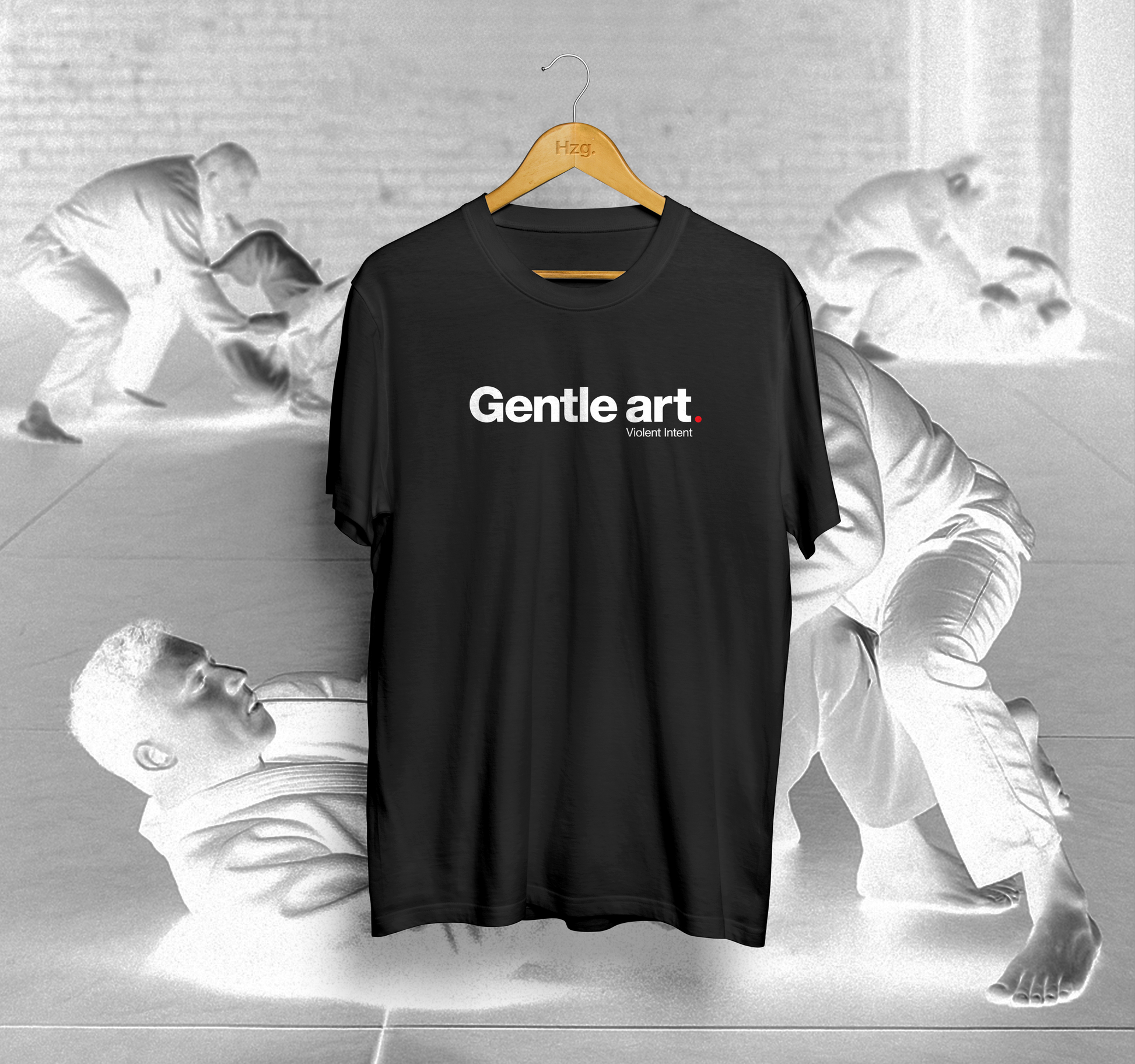 Black t-shirt with 'Gentle art' text on a hanger against a gray background with artistic figures.