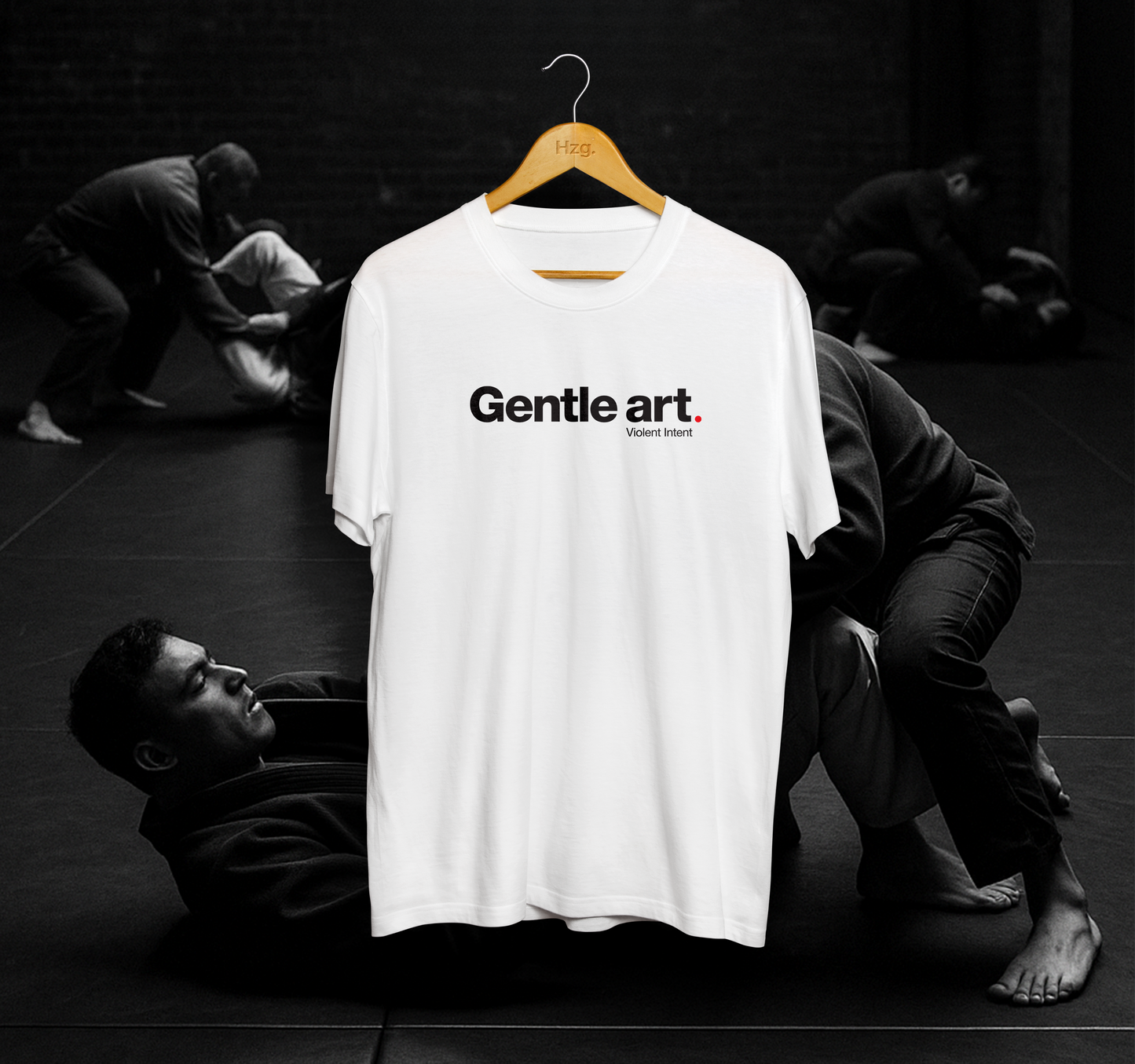 White t-shirt with 'Gentle art' text on a hanger against a black and white background