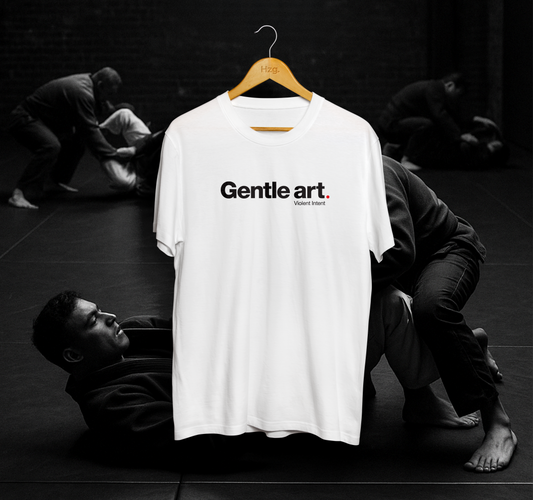 White t-shirt with 'Gentle art' text on a hanger against a black and white background