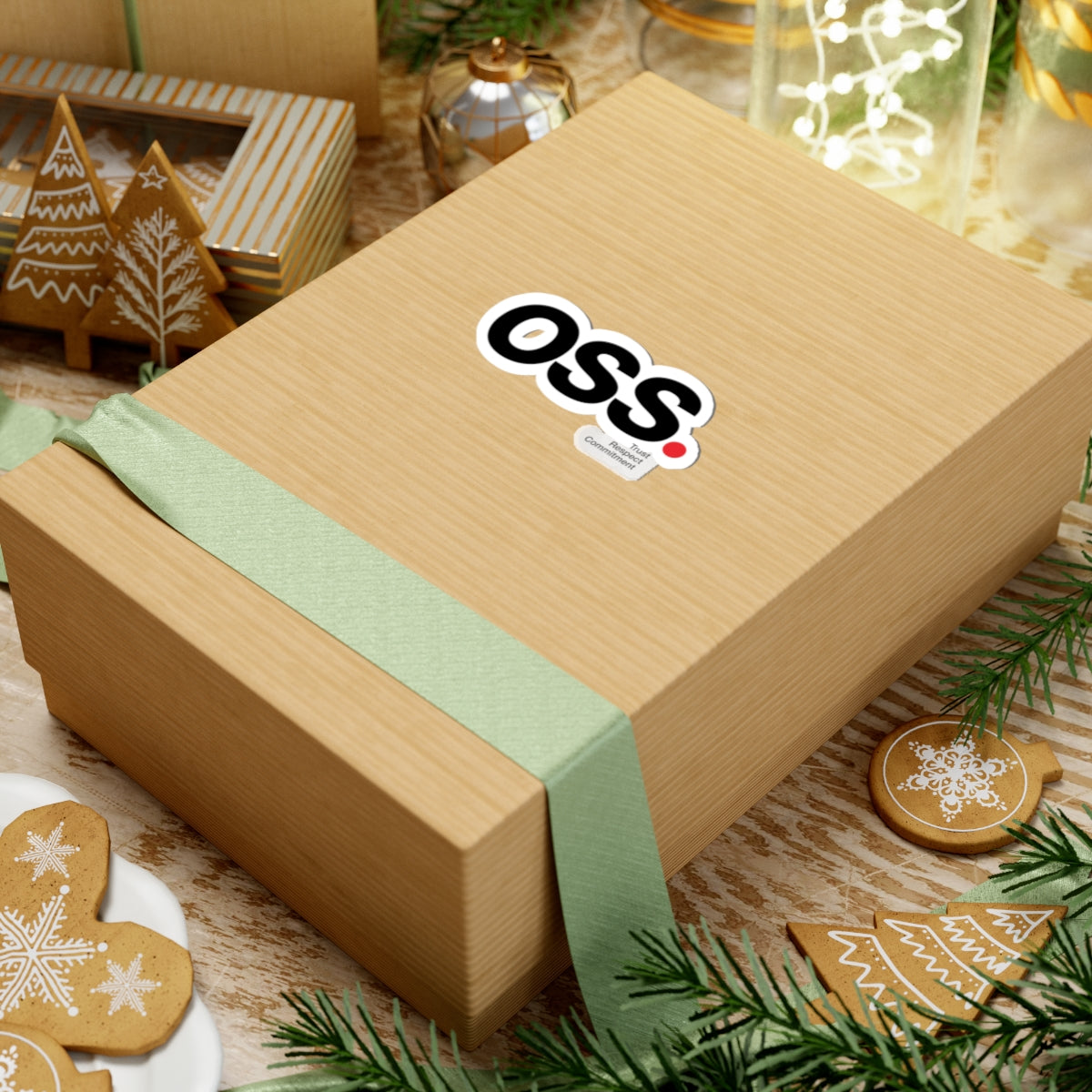 Wooden gift box with a green ribbon and OSS logo on a festive background with cookies and decorations.